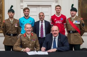 L to R Lcpl Frankie McCabe, jake Gallagher, Shahid Azeem, Sean McGinty Sgt Alan Roberts. Major General John Crackett and Brian Barwick. The National League, the competition which covers the fifth and sixth tiers of football in England & Wales, has joined an ever growing list of leading companies and organisations in signing up to the Armed Forces Corporate Covenant. The National League consists of 68 clubs, arranged over three divisions – National, North and South. Today’s specific signing event took place in the iconic military setting of Horse Guards and involved the Competition itself. Today’s signing followed the November board meeting and Chairman Brian Barwick signed on behalf of The National League. To further recognise the close link between The Army and the game of football two football players from Aldershot Town, the home of the British Army, were present alongside soldiers from the London Irish Regiment and HQ London District. 100 years ago members of these units were among those soldiers who took a break from hostilities on the Western Front to play the “beautiful game” – the First World War Christmas football match has become an icon of how sport can transform lives, even those enduring the horrors of the worst of war. Photographer: Sergeant Rupert Frere RLC